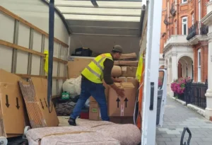 A man is standing inside the van and arranging packed boxes.